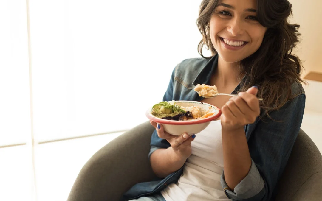 women sitting on a chair eating a salad